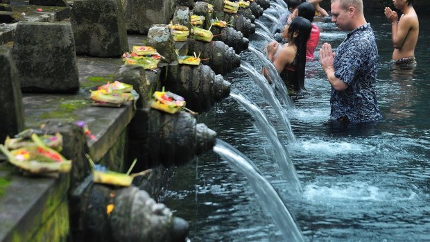 Healing waters: A visitor joins the Balinese at the Pura Tirta Empul.