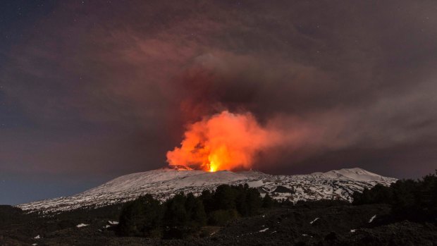 Snow-covered Mount Etna spews lava during an eruption in the early hours of Thursday.