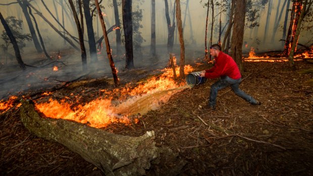 Adam Watkins working to save his home near Lancefield, north of Melbourne, earlier this month.