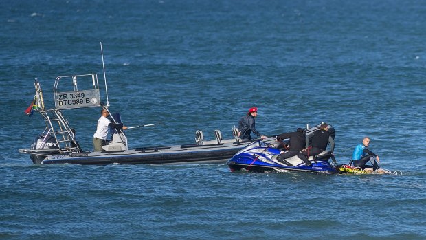 Mick Fanning looks on from the safety of a jet-ski as the water safety team continues to look for the shark that attacked him during the final of the JBay Open.