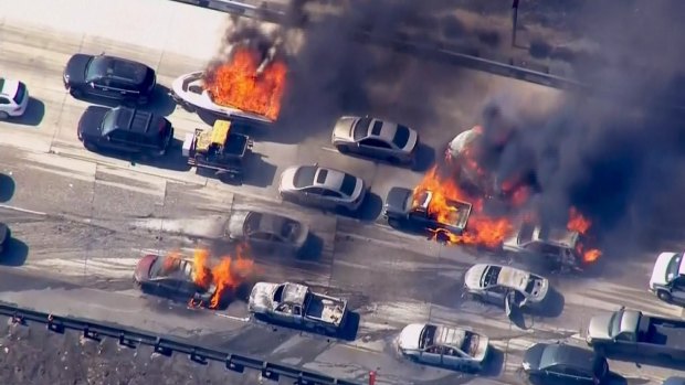 Cars are shown burning on the Interstate 15 freeway
