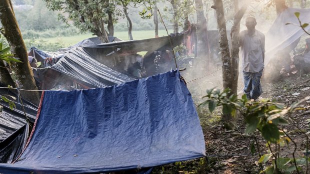 A Rohingya man stands next to makeshift tents at a newly set-up refugee camp at Balukhali in Cox's Bazar, Bangladesh.