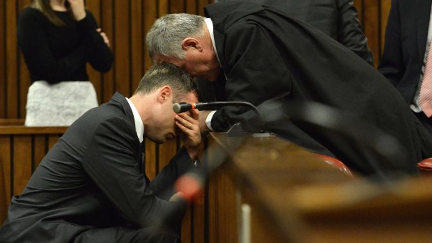 A crying Oscar Pistorius, left, is comforted by his defence lawyer, Barry Roux, on the third day of  sentencing hearings.