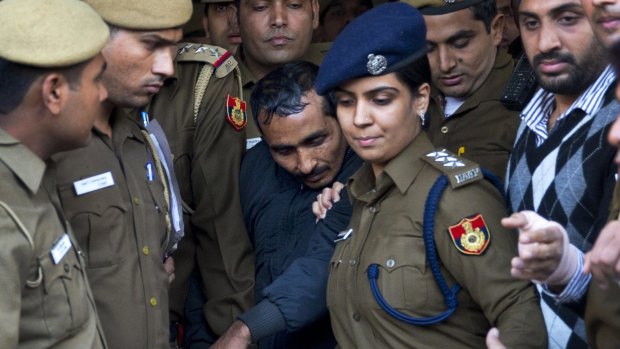 Shiv Kumar Yadav (centre), a driver for the international taxi-booking service Uber, is surrounded by police as he is brought out of court in New Delhi in 2014.