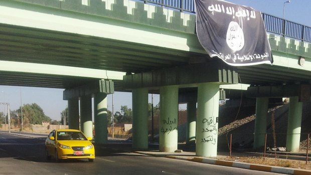 A flag of the Islamic State hangs over the entrance of the northern Iraqi city of Mosul.