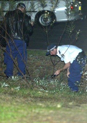 Police search the area surrounding Forresters Beach following the killing.