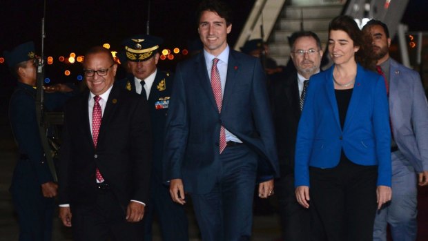 Canadian Prime Minister Justin Trudeau with Peru's Minister of Energy and Mines Gonzalo Tamayo, left, and Canada's ambassador to Peru, Gwyn Kutz, as he arrives in Lima for APEC.