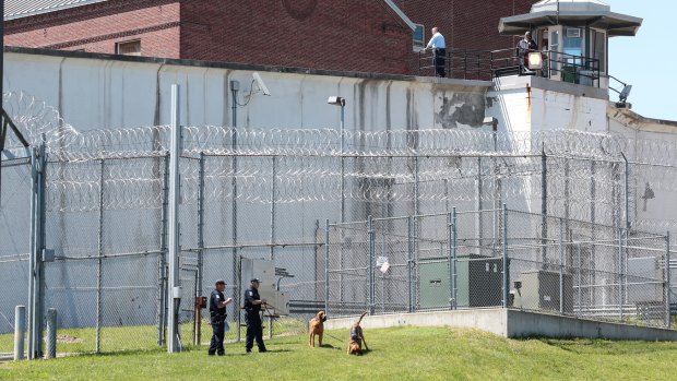 Law enforcement officers with bloodhounds at one of the entrances to the Clinton Correctional Facility in New York on Saturday.