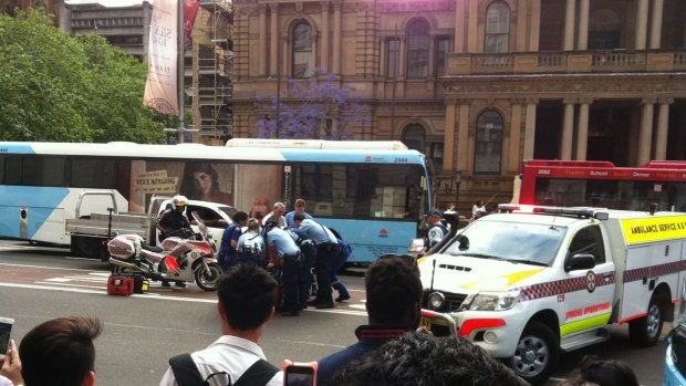 Police subdue a man on George Street, outside Town Hall, on Monday afternoon. 