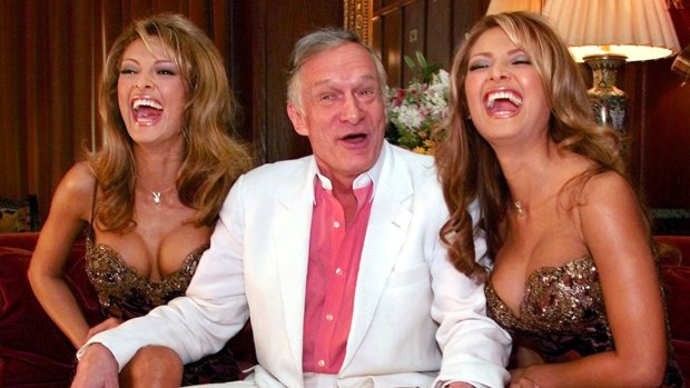 Playboy Magazine founder Hugh Hefner poses with January 2000 Playmates Carol, left, and Darlene Bernola, 