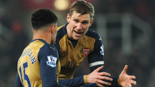 Frustration: Arsenal captain Per Mertesacker, right, and Alex Oxlade-Chamberlain plot a way through the Stoke defence.