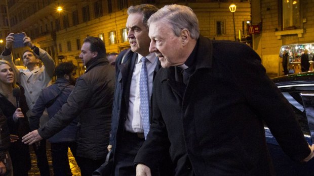 Cardinal George Pell, right, arrives at the Quirinale holtel in Rome.