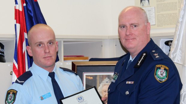 Chris Sheehy (left) receives a bravery award from Newtown Police Commander Simon Hardman in September 2015. Mr Sheehy was under investigation for alleged drug taking after a complaint by Mr Hardman. 