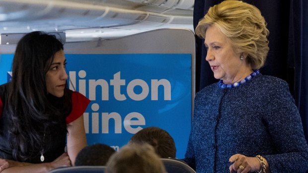 Hillary Clinton speaks with Huma Abedin aboard the campaign plane to Iowa on Friday.