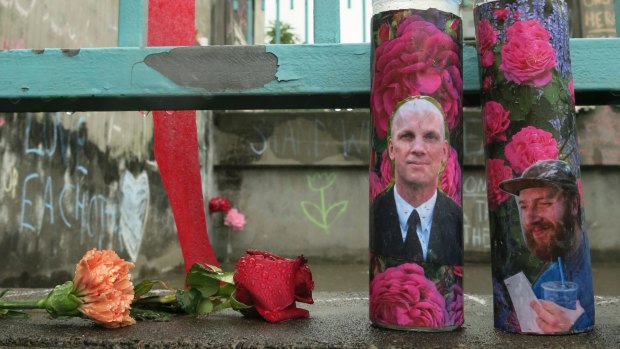Votive candles bearing the photos of two men who were fatally stabbed in Portland, Oregon.