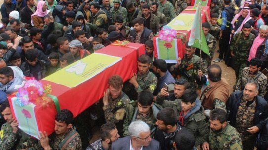 Fighters from the predominantly-Kurdish Syrian Democratic Forces carrying the coffins of their comrades, who were killed Tuesday by a misdirected airstrike by the US-led coalition.