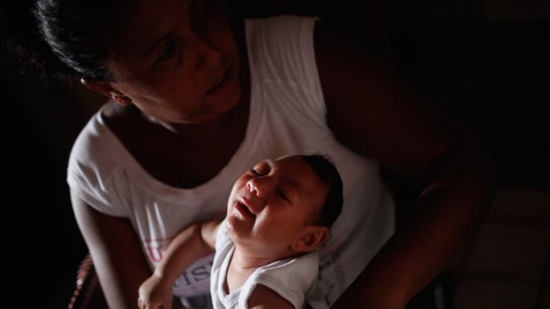 Alice Vitoria Gomes Bezerra, 3-months-old, who has microcephaly, is held by her mother.