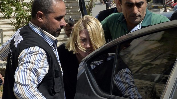 Lebanese policemen escort Tara Brown from a Lebanese courthouse before the deal was struck.