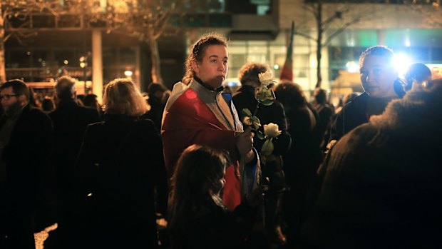 A woman holds a flower during a rally outside the Stade de France on Thursday.