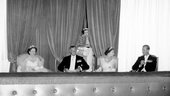 The Royal Party at the Princess Theatre for the Royal Command opera performance 1 March 1954.
Left to right are Lady Brooks, the Governor Sir Dallas Brooks, the Queen and the Duke of Edinburgh. The Queen's lady-in-waiting Lady Alice Egerton is entering the box through the drapes in the background, distracting the Queen from the performance.
