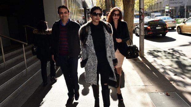 Pankaj Oswal (left) and his wife Radhika (right) and daughter Vasundhara leave court in Melbourne: There is little doubt it was the bank that blinked first.