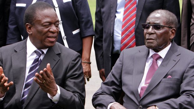 Emmerson Mnangagwa, left, then Vice President of Zimbabwe chats with Zimbabwean President Robert Mugabe  in 2014.