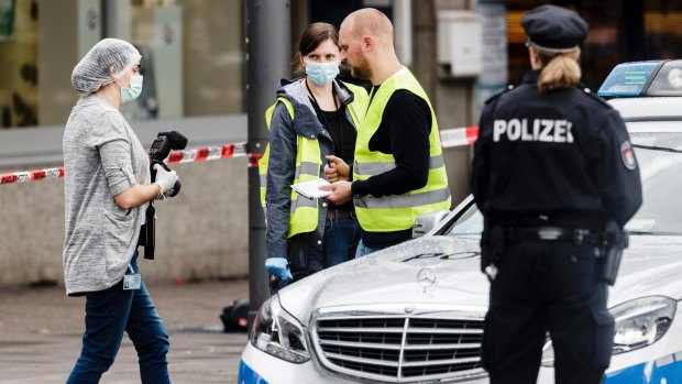 Police officers secure evidence in front of the supermarket in Hamburg.