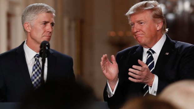 President Donald Trump applauds as he stands with Judge Neil Gorsuch after announcing Gorsuch as his nominee for the Supreme Court. 