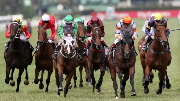 Damien Oliver (orange cap) takes Le Roi to the front in the Queen Elizabeth  Stakes.