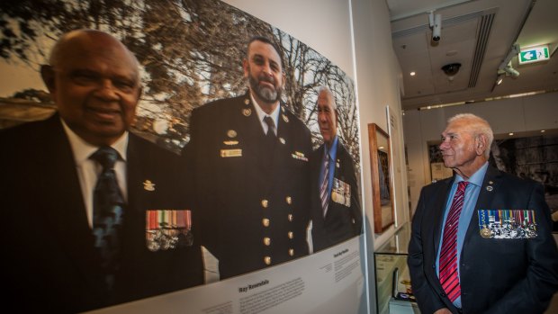 Roy Mundine looks at a photo of himself in the Australian War Memorial exhibition, For Country, for Nation.