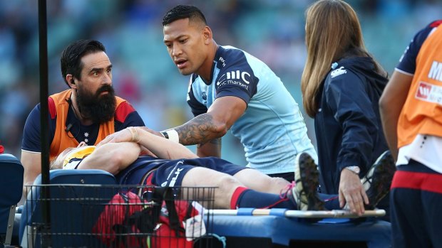 Concern: Israel Folau talks to Reece Hodge as he is taken from the field.