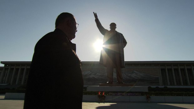 Joe Dresnok in front of a statue of the late president Kim Ul Sung as seen in the documentary Crossing the Line.