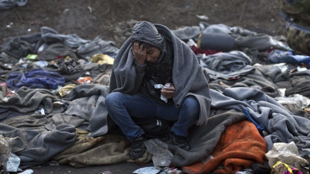A boy attempts to keep warm as he waits to cross from Serbia to Croatia on Saturday.