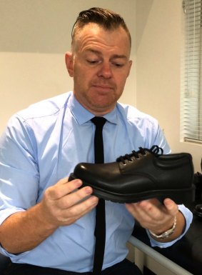 Brendan Brown, of A Step Ahead Podiatry, examines a school shoe.