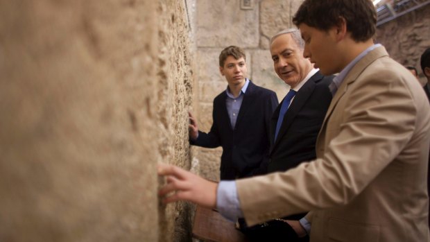 Israeli Prime Minister Benjamin Netanyahu, centre, prays with his sons Yair, background, and Avner, right, in Jerusalem's Old City. 