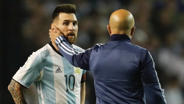 Argentina's Lionel Messi, left, is comforted by coach Jorge Sampaoli.