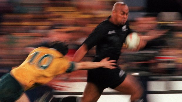Jonah Lomu evades the tackle of Stephen Larkham during the "greatest game of all time" in Sydney, 2000.