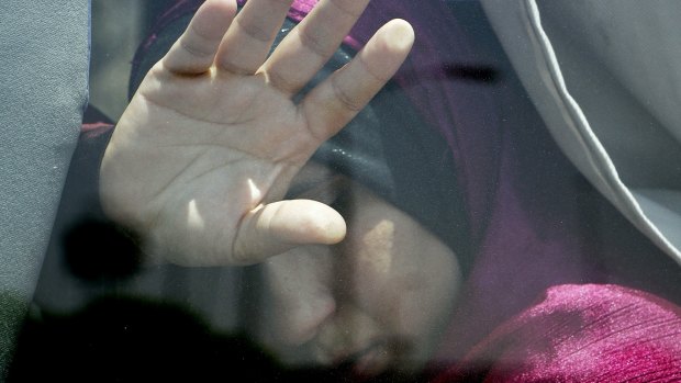 A relative of a passenger on the EgyptAir flight puts her hand on the window from inside a bus at Cairo airport.