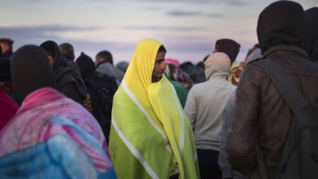 Migrants who had crossed the Serbian border into Hungary the previous evening try to keep warm at dawn in Morahalom, Hungary. 