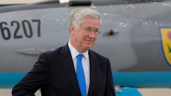 Britain's Defence former Minister Michael Fallon walking next to a Soviet era built MIG21 jet fighter at the Mihail Kogalniceanu air base, Romania in June.