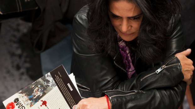 Investigative journalist Lydia Cacho holds a book written by murdered journalist Javier Valdez as she prepares to read from it during a protest against the killing of reporters.