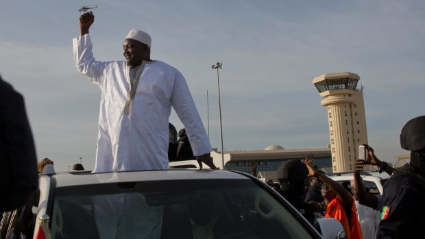 Gambia's new President has finally arrived in the country, a week after taking the oath of office abroad.
