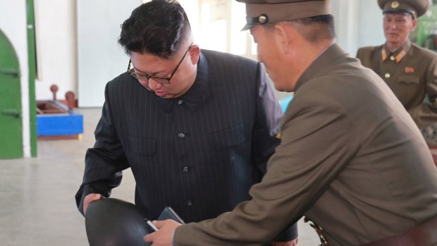 North Korean government leader Kim Jong-un, left, inspect a part at an undisclosed location in North Korea. 