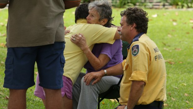 People comfort a woman who escaped an apartment in the marina building as it collapsed. 