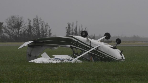 An aircraft lies overturned by the power of Cyclone Debbie at Bowen Airport.