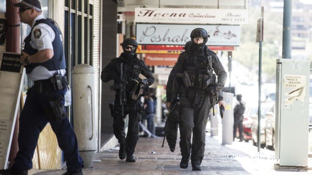 SWAT police walk up George Street during a brothel siege in Liverpool.