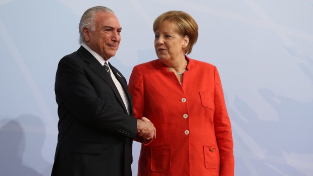 German Chancellor Angela Merkel greets Brazilian President Michel Temer at the G20 summit being held in her home town this weekend.