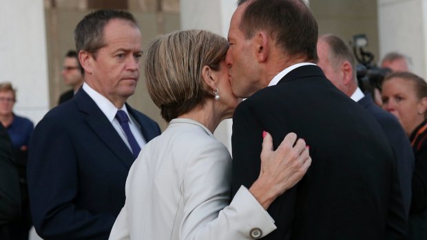 Unity: Bill Shorten looks on as Tony Abbott kisses Julie Bishop.