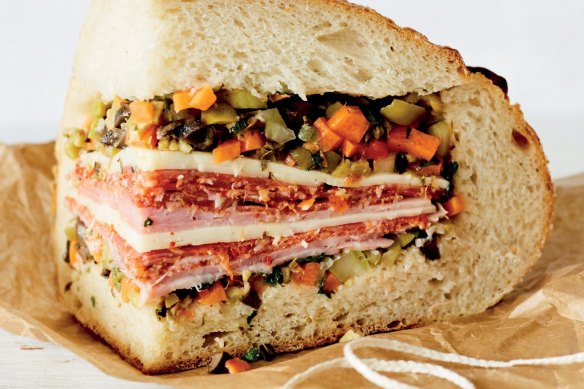 A portion of muffuletta piled with deli meats.