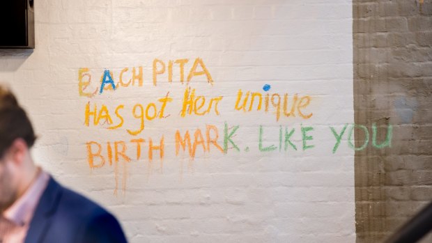 Statements like 'Each pita has a unique birthmark' are written all over the walls.